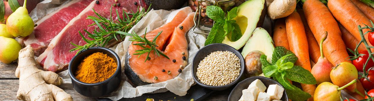 Ein Tisch voll mit vielen Zutaten wie Fleisch, Fisch, Gemüse und Gewürzen